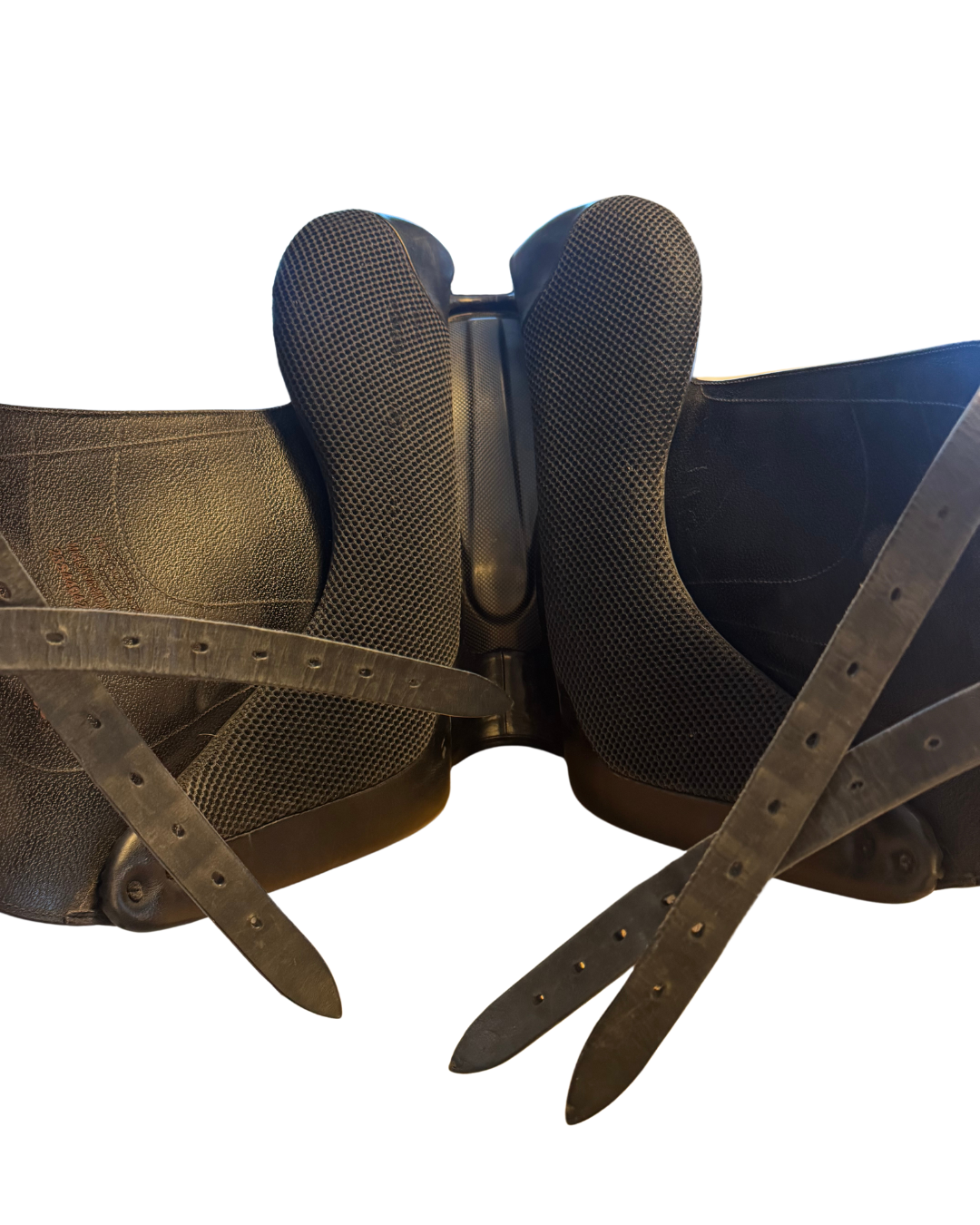 Close-up of a horse saddle with leather straps on a white background