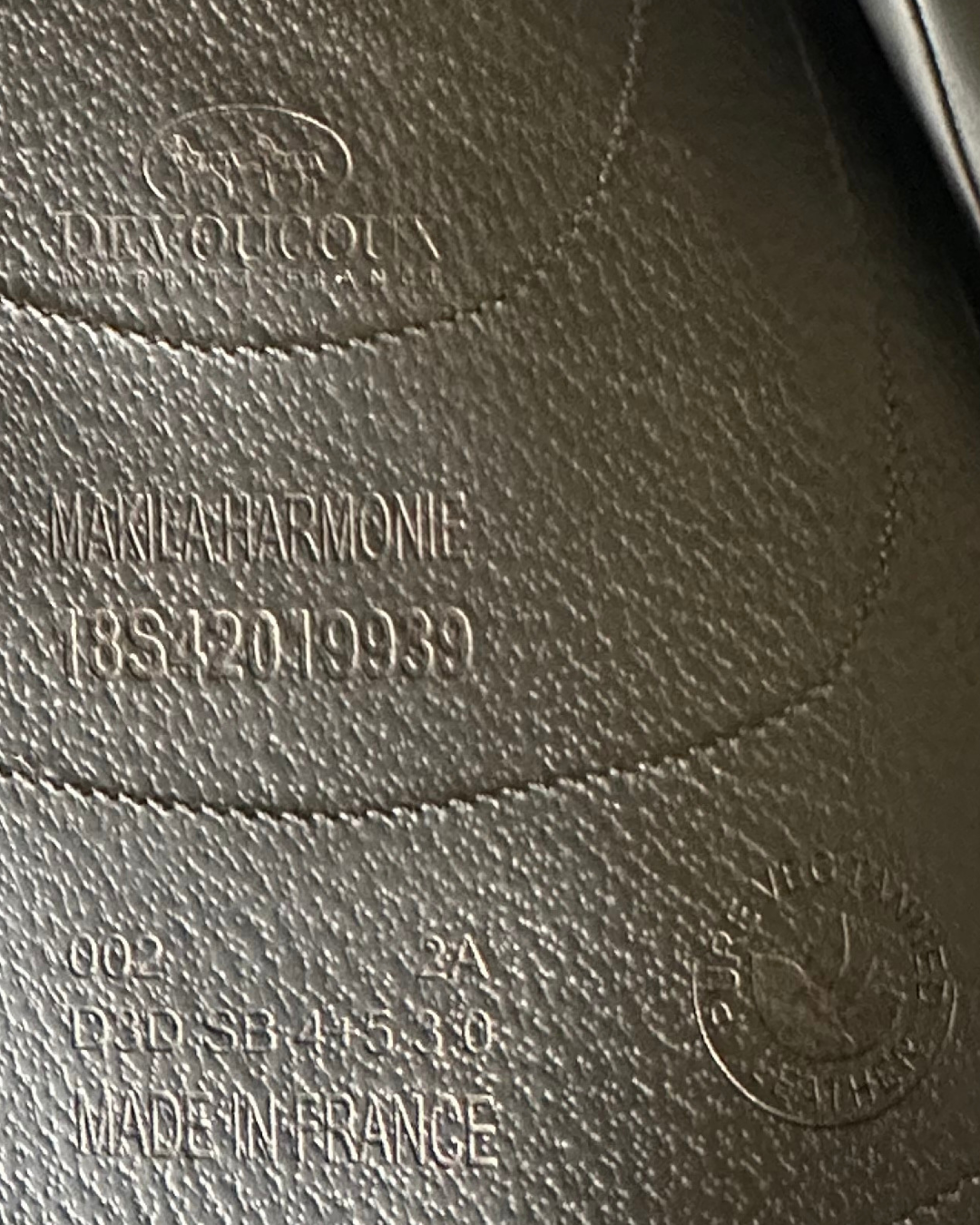 Close-up of a leather horse saddle with branding and text